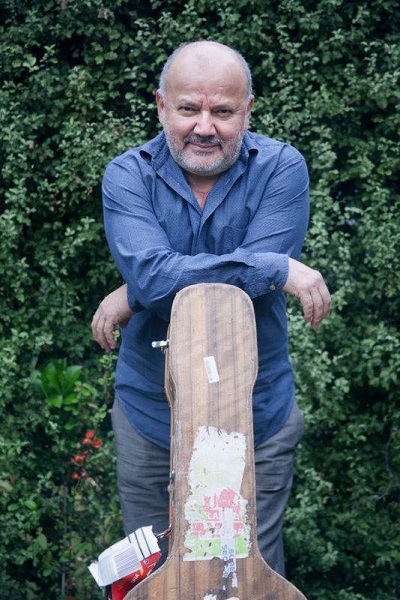 Horacio Salinas leaning on a guitar case