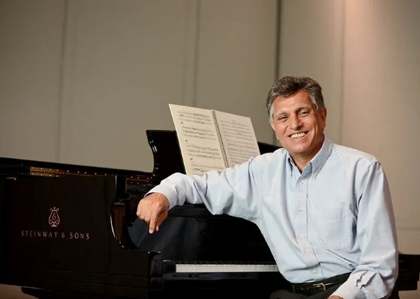 Photo of Reza Vali sitting at a piano